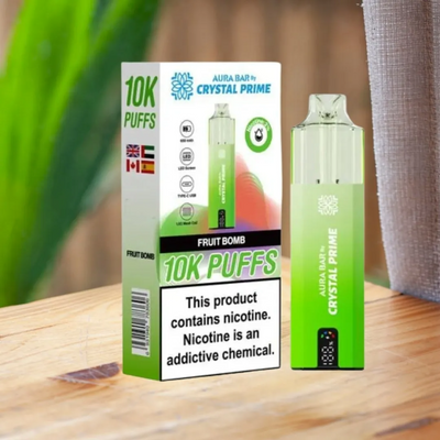 Crystal Prime 10000 Puffs reusable vape device with Fruit Bomb flavor in green and black packaging on wooden surface